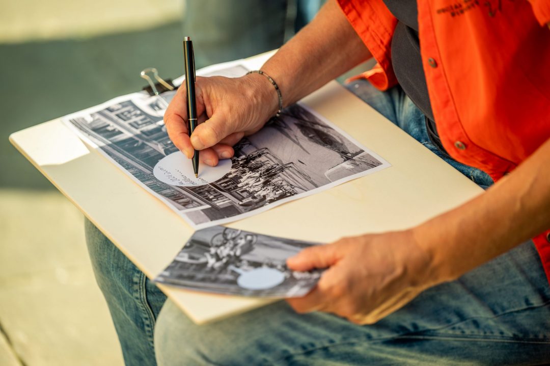 Partizipationsaktion beim Projekt „HMH Geschichte unterwegs“: Eine Person schreibt Kommentar in eine Sprechblase auf ein historisches Foto.