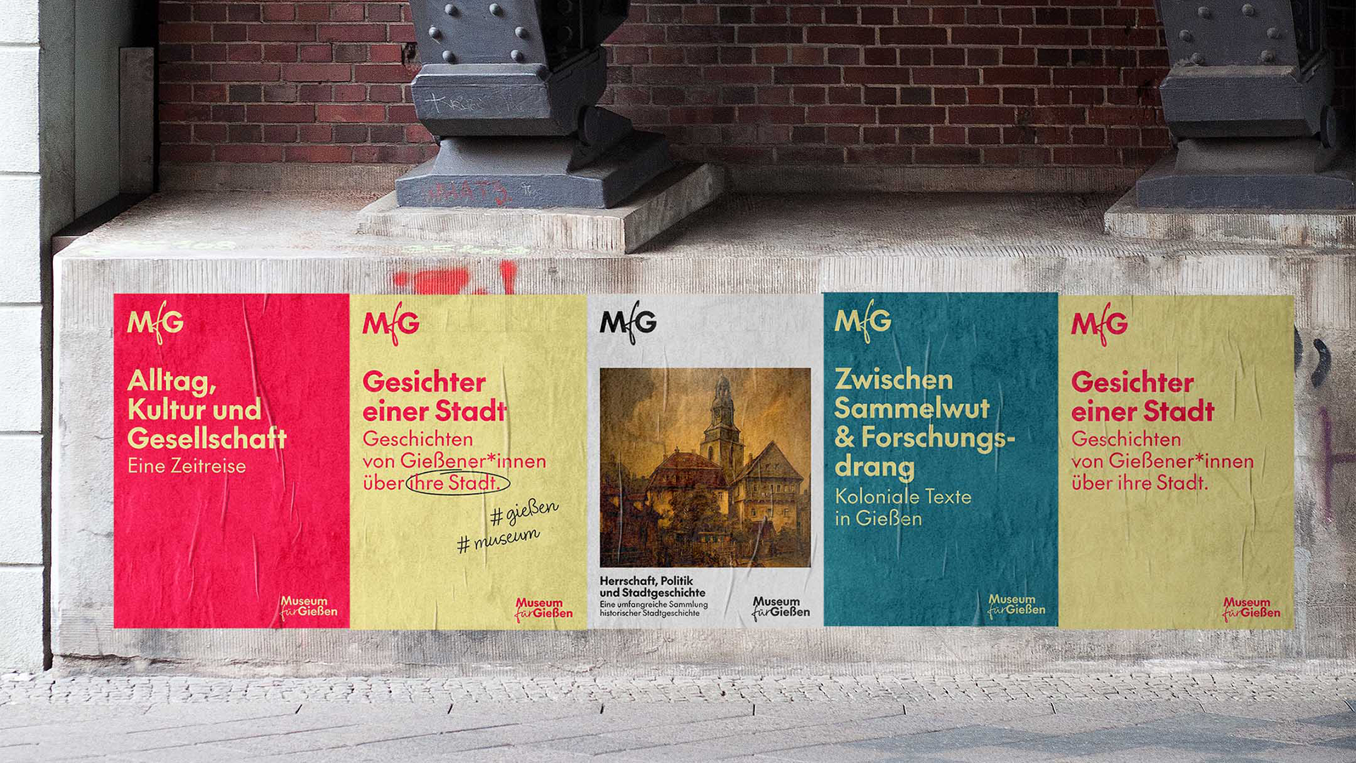 Straßenplakate unter einem Brückenbogen zeigen vier bunte Poster des Museums für Gießen. Von links nach rechts: rotes Plakat mit der Aufschrift „Alltag, Kultur und Gesellschaft – Eine Zeitreise“; gelbes Plakat mit roter Schrift „Gesichter einer Stadt – Geschichten von Gießenerinnen über ihre Stadt“; weißes Plakat mit einem historischen Gemälde und dem Text „Herrschaft, Politik und Stadtgeschichte – Eine umfangreiche Sammlung historischer Stadtgeschichte“; türkisfarbenes Plakat mit gelber Schrift „Zwischen Sammelwut & Forschungsdrang – Koloniale Texte in Gießen“; erneut ein gelbes Plakat mit „Gesichter einer Stadt – Geschichten von Gießenerinnen über ihre Stadt“.