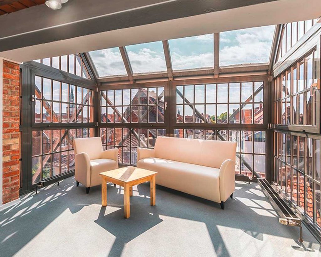 Raumszene einer Gesprächsecke im Tagungsgebäude der ba Wolfenbüttel. Wintergarten im Industriearchitektur-Stil. Hell erleuchtet.