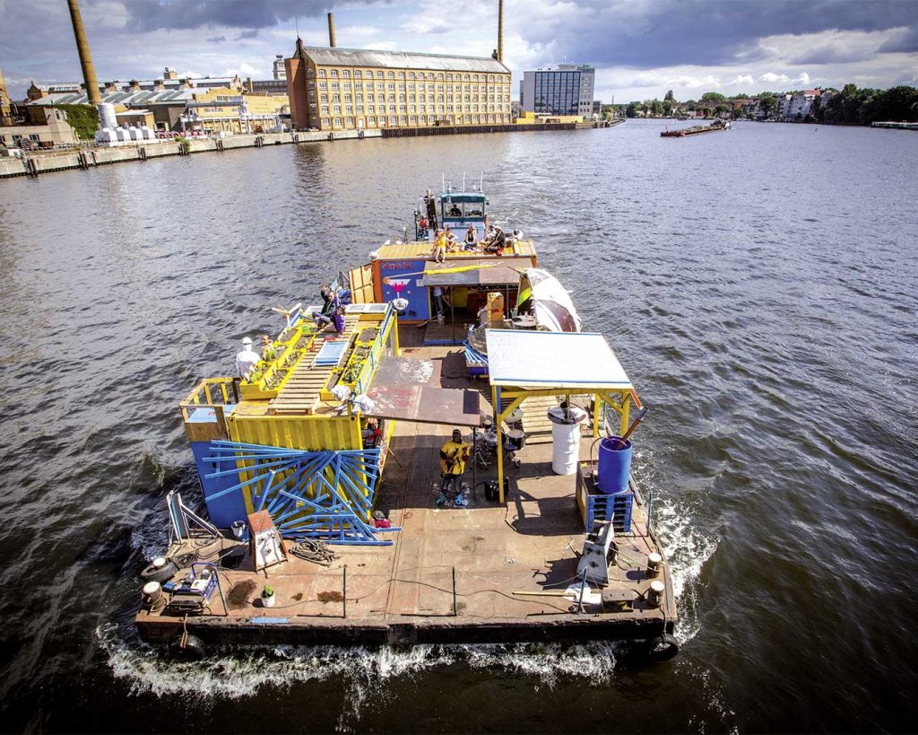 Ausgebautes Floß von oben auf dem Fluss Spree. Im Hintergrund das andere Ufer.