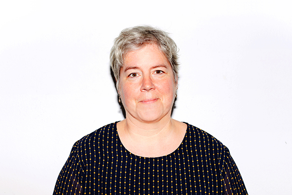 Portrait von Beate Brüggmann, Person mit silbergrauen Haaren und schwarzem Shirt mit Punktmuster