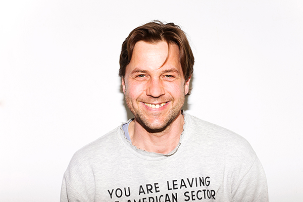 Portrait von Christian Lagé, braunhaarige Person mit grauem Shirt