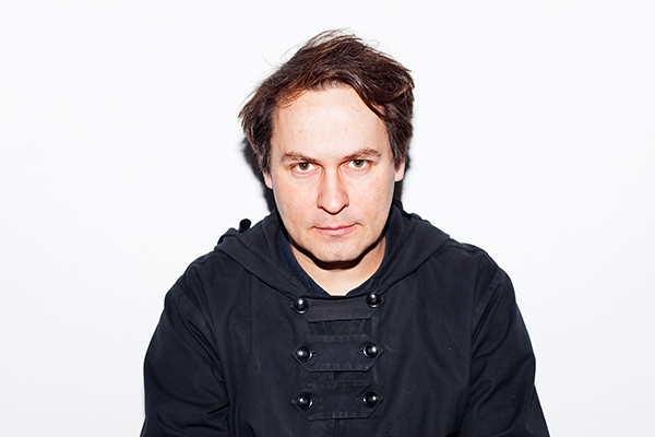 Portrait von Steffen Schuhmann, braunhaarige Person mit schwarzem Kapuzenshirt und Doppelknöpfen