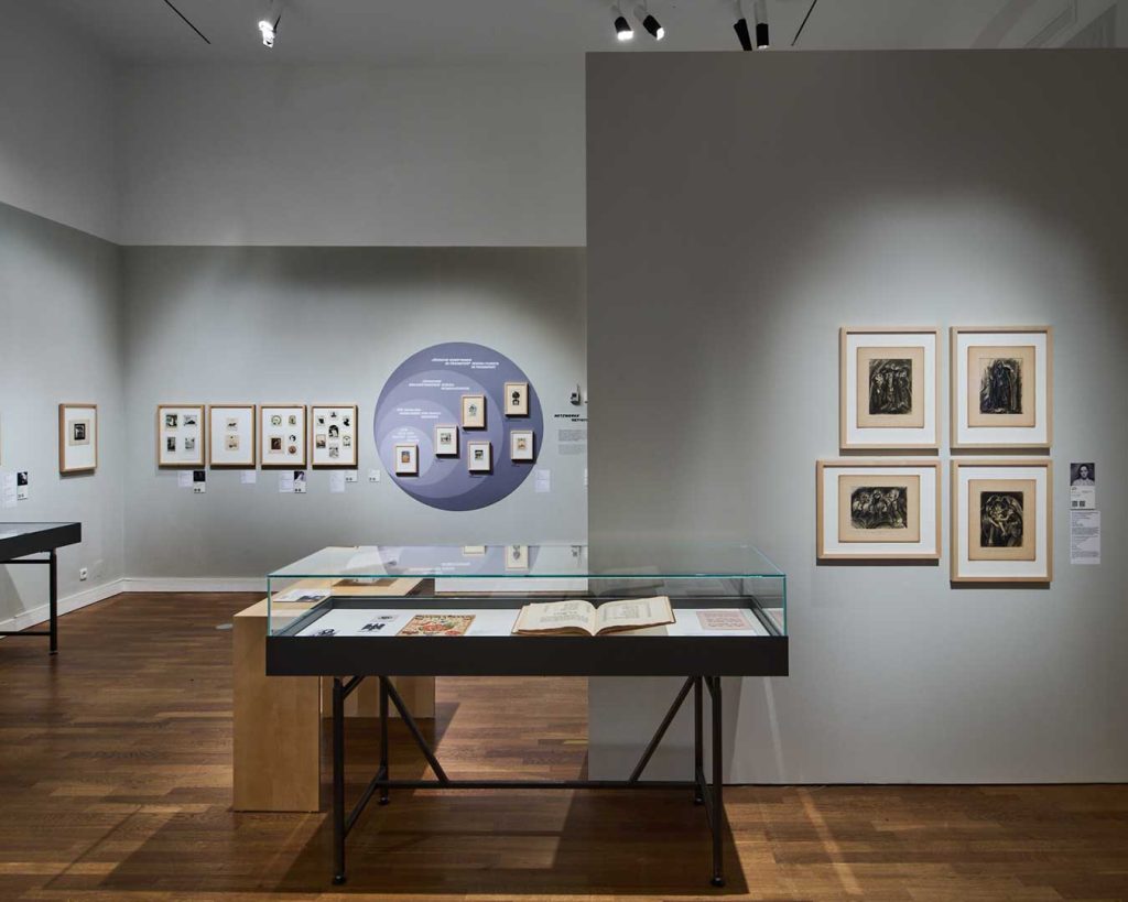 Raumansicht Ausstellung Widerstände. Werke auf grauen Wänden. Im Hintergrund ein Zeitstrahl.