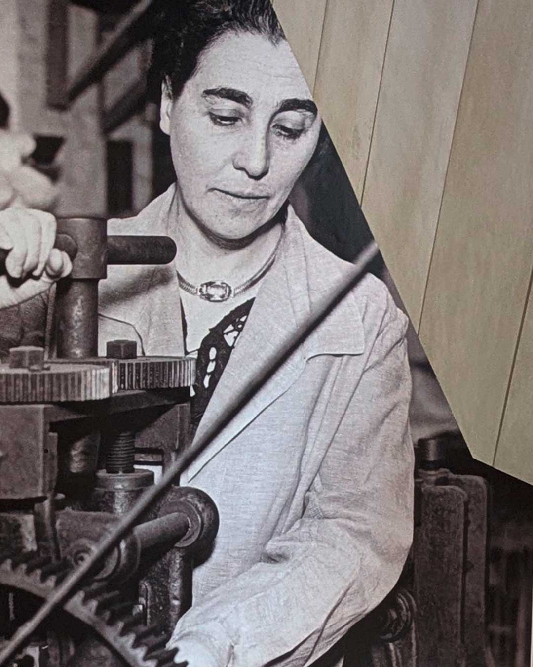 Blick in Treppenaufgang mit Fototapete. Schwarzweißbild: Eine Person bedient eine Maschine.