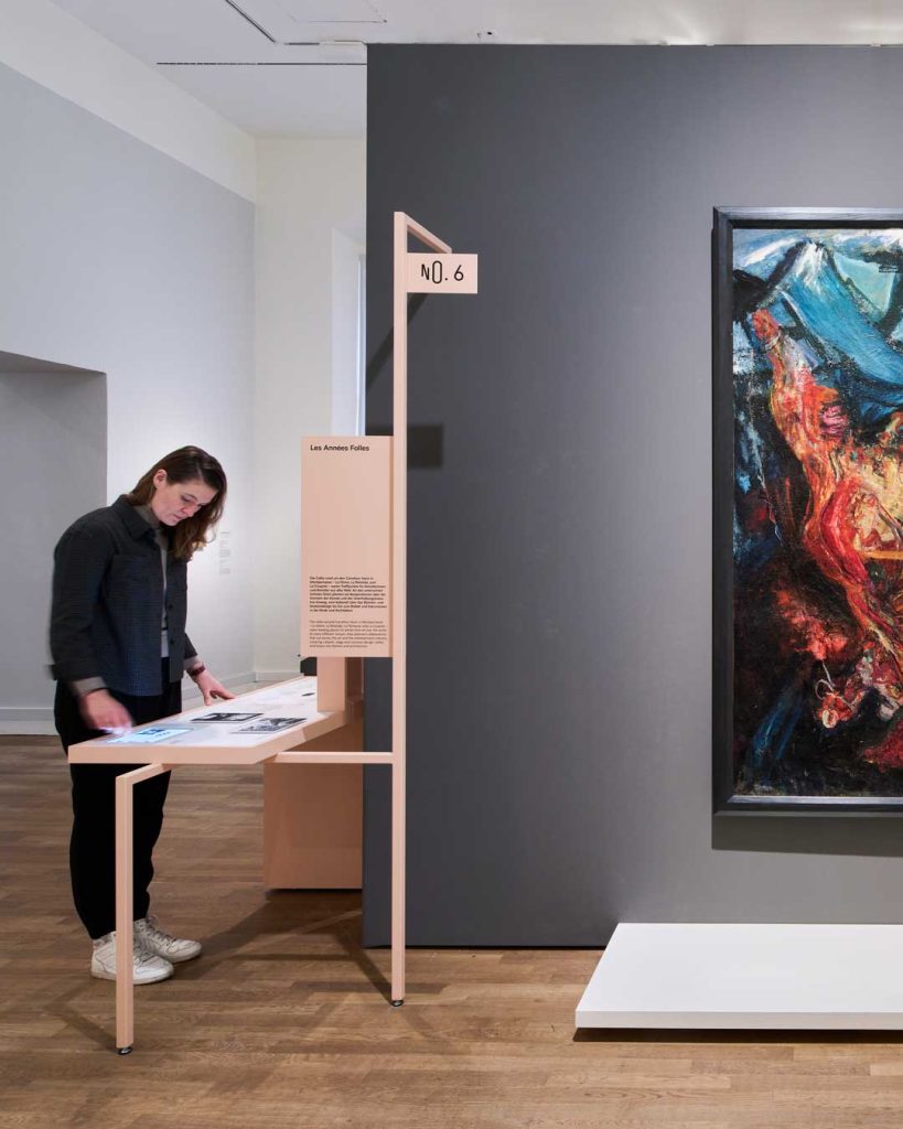 Eine Person betrachtet Texte und Grafiken in einem Ausstellungsraum.