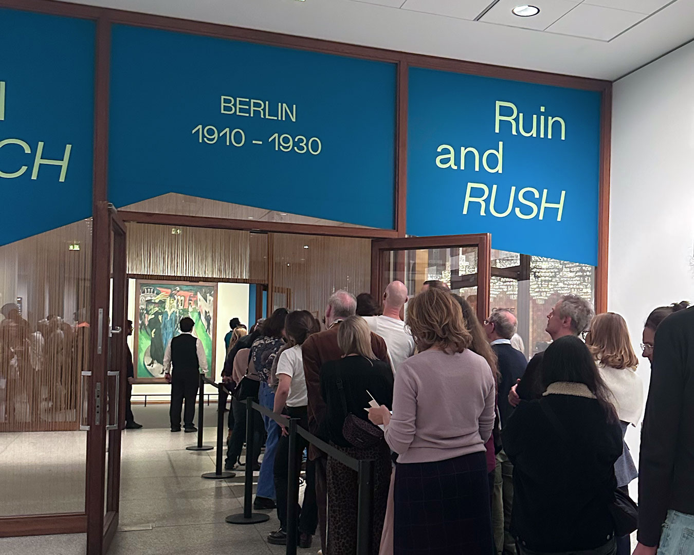 Ausstellungsgäste am Eingang zur Ausstellung in der Neuen Nationalgalerie Berlin. Darüber der Ausstellungstitel Ruin und Rausch